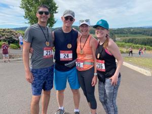 Four smiling people posing for a photo after completing a 5k run.