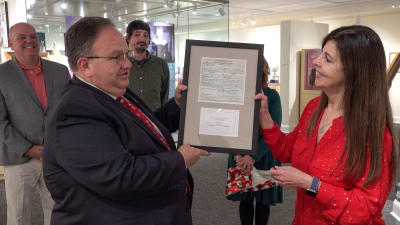 Register of deeds presenting copy of restored certificate to director Lynell Seabold