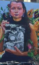 Mural (2018) depicting a member of the Narragansett Indian Tribe holding a photo of Princess Red Wing, a Narragansett/Pokanoket-Wampanoag elder who founded the Tomaquag Museum (Exeter).  Located at 32 Custom House Street.