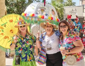 Group of women dressed in tropical clothes with umbrellas