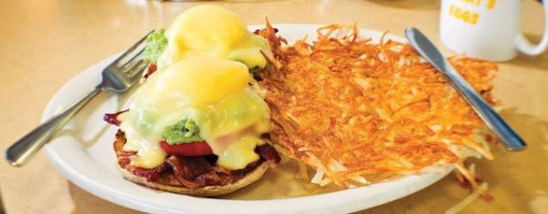 A breakfast plate with two eggs Benedict with a side of hash browns from Fat Nat's Eggs.