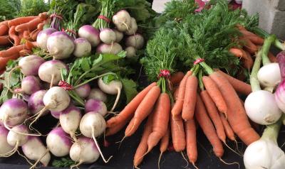 Vegetable stand with onions and carrots