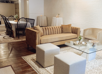 A wide view of a hotel lobby with a couch, chairs, coffee table, and dining table.