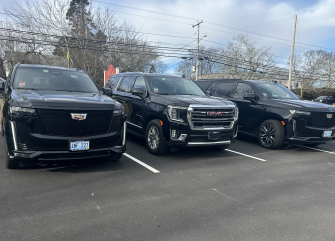 Three luxury vehicles parked in a parking lot.