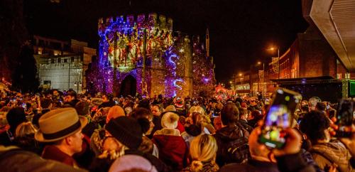 Crowd watching Christmas Market light projection show on bargate