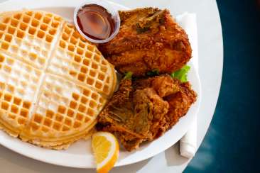 A table plated with chicken and waffles from the Home of the Chicken and Waffles in Oakland, CA