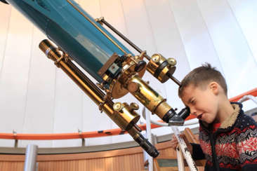 A young boy looking through a telescope at the Chabot Space & Science Center in Oakland, CA