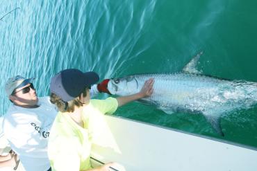 Father and son with tarpon in the water