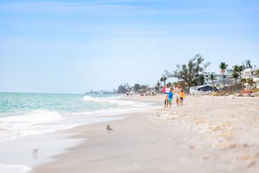 Family walking on the beach on Manasota Key in Punta Gorda/Englewood Beach.