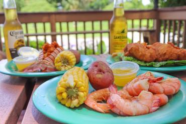 Plates of seafood with corn, potatoes, and beer at Peace River Seafood