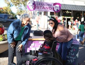 Grandma visits with two women, one in a wheelchair, in Downtown McKinney.