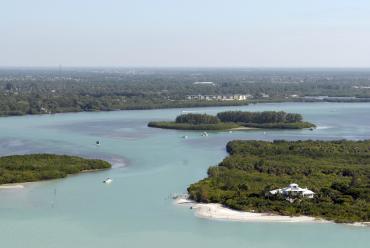 Aerial view of boats in blue water, Gulf Islands, and mainland Punta Gorda/Englewood Beach