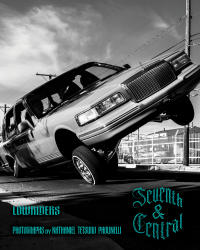 Black and white image of a lowrider car performing a high tilt with one wheel lifted.