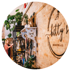A visitor browsing an artisan shop with historic brick walls