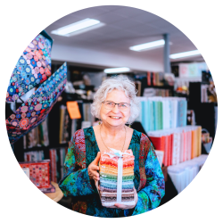 Shopkeeper smiles to the camera at a quilt shop