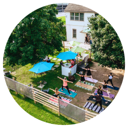 Drone shot of wellness centre with restaurant dining outside and yoga class on the grass