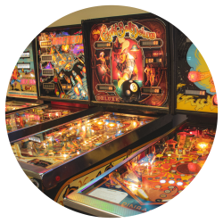 A row of pinball machine, lit up and glowing