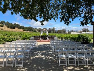 Wedding ceremony setup with a sunny vineyard backdrop