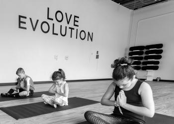 Family with hands at heart center at Love Evolution Studio
