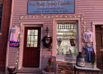 Store front of You Make Scents. Red door with lights drapped around and various clothing hanging