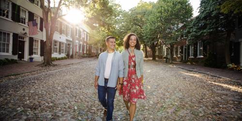 A couple walking on a cobblestone street in Alexandria, VA