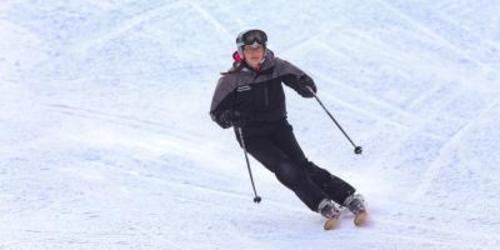 Person in winter gear skiing down a snowy hill at Ski Sawmill Family Resort
