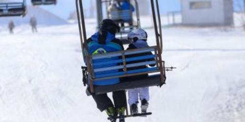 Two people riding on a ski lift at Blue Knob All Seasons Resort 