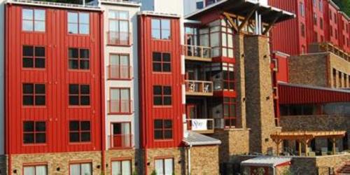 Exterior of the side of the five story Bear Creek Mountain Resort with red paneling and windows on every floor