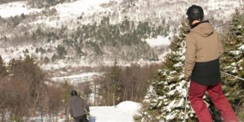 Person in snow gear on a snowboard at the top of a mountain at Blue Mountain Resort in the Lehigh Valley