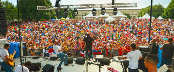 Band playing on stage in front of massive crowd at Festival Latino