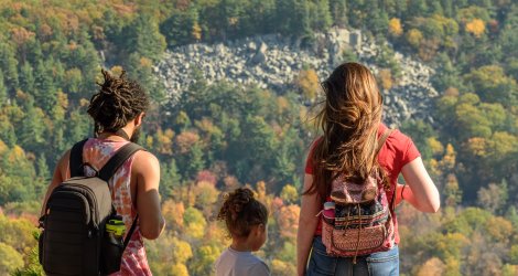 A young couple with a small child overlook fall scenery and rocks at Devil's Lake State Park.
