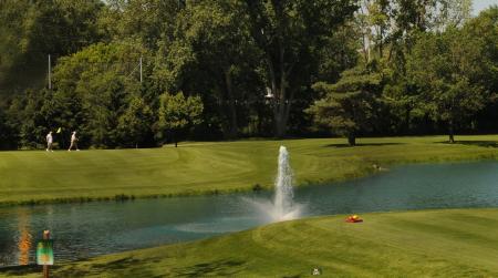 Fountain spraying water in a pond on a golf course