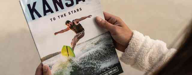 Woman holds a Kansas travel guide