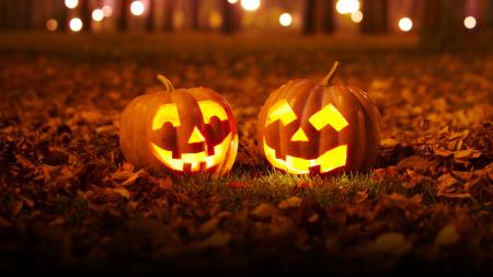 This image shows two jack-o-lanterns with candles lit inside them.