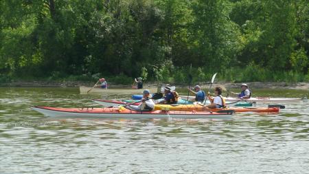 4 pairs of two kayaking on the calm Fox River water