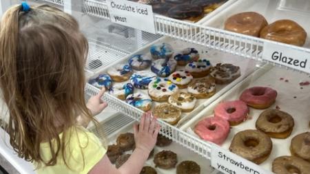 Our three year old trying to decide on which donut at Reds Donuts in Danville, IN