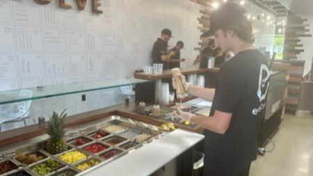 Employee of Everbowl creating the layers of an acai bowl