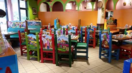 Inside Buena Vista in Ardmore. Colorful chairs are placed around large tables.