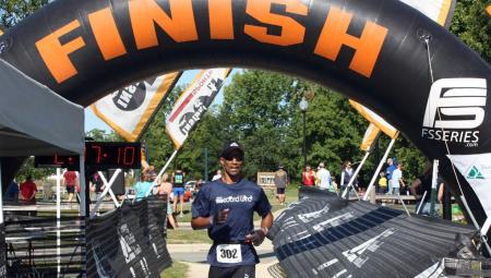 A runner crossing the finish line at a race in Johnston County, NC.