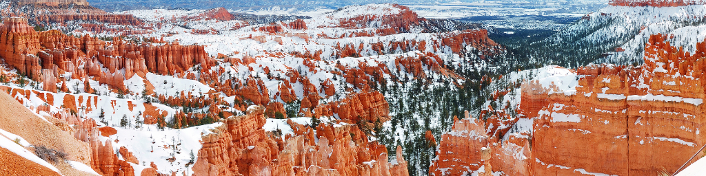 Ridges and hoodoos of red rock formations in Bryce Canyon National Park in Southern Utah dusted with snow.