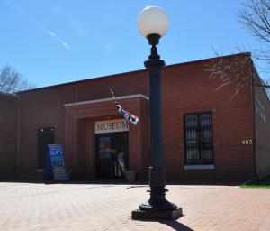 Exterior of the Finney County Historical Museum, a red brick building with an antique light post in front