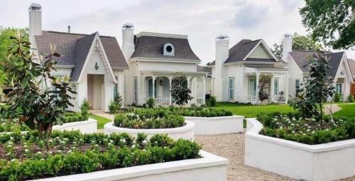 beautiful white cottages with chimneys and flowerbeds found at The Bingham Estate in Downtown McKinney