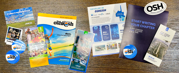 Collage of Oshkosh Collateral on display at the Discover Oshkosh/Oshkosh Aviation Park booth