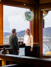 picture of a couple chatting at the standing side bar at Skeeter BBQ. Enjoying drinks and chatting while waiting for food.