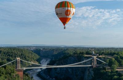 A green and orange striped balloon over the Clifton Suspension Bridge