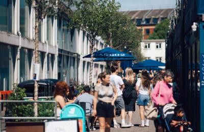 People walking alongside Cargo 2 shops in Wapping Wharf on Bristol's Harbourside - credit Shotaway