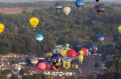 Balloons lifting off in a mass ascent at Bristol International Balloon Fiesta 2025