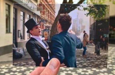 A view of Clare Street in Bristol's Old City, with a hand holding a photograph of actors David Tennant & Neil Patrick Harris filming one of the 2023 Doctor Who specials in the same spot - credit Logan Walker