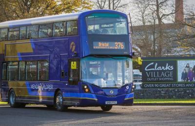 A purple and beige-coloured Mendip Explorer 376 bus parked at Clarks Village in Street, Somerset - First Bus