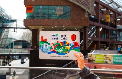 Hand holding a Love Bristol Gift Card shopping voucher in Cabot Circus, central Bristol - credit Bristol BIDs